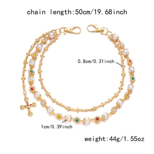 Detail of hip-hop pants chain with colorful stones, pearls, and golden cross pendant
