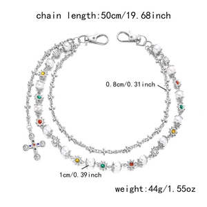 Detail of hip-hop pants chain with faux pearls, rhinestone flowers, and cross pendant