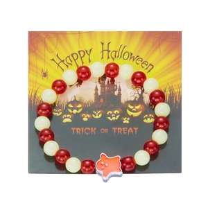 Luminous Halloween bracelet with red beads and ghost pumpkin charm on decorative card
