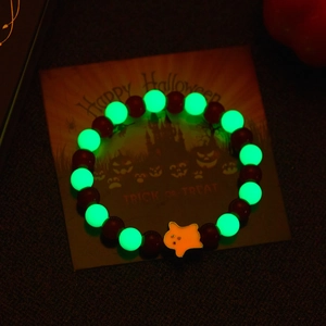 Luminous Halloween beaded bracelet with a glowing green ghost charm in the dark