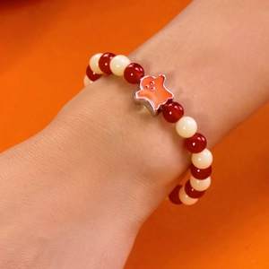 Close-up of Halloween beaded bracelet featuring red and white beads with a ghost charm