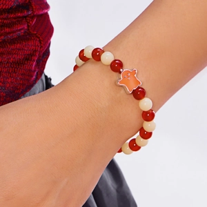 Detail of Halloween beaded bracelet featuring red beads and a cute orange ghost charm