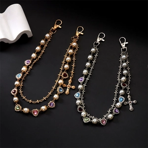 Detail of hip hop pants chain with colorful heart gems, pearls and cross charms