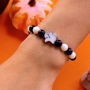 Detail of Halloween beaded bracelet with ghost charm and black and white beads on wrist