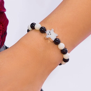 Close-up of a Halloween beaded bracelet with black and white beads and a ghost charm