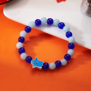 Detailed view of luminous blue beads and blue ghost charm on a Halloween bracelet