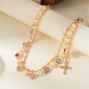 Detailed view of gold multi-layer chain with colorful heart crystals and white pearls