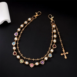 Detail of vintage gold layered chain with colorful heart charms and pearls for jeans