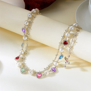 Detailed macro view of pearl trouser chain featuring multi-colored gemstones and crosses