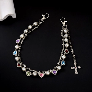 Detail of hip hop trouser chain with layered pearls, colorful hearts, and cross pendant