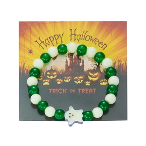 Close-up of Halloween beaded bracelet featuring a white ghost charm and green glowing beads
