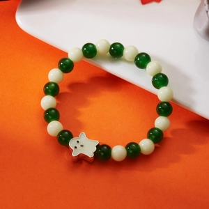 Macro shot of Halloween bracelet featuring glowing beads and white ghost charm