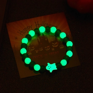 Luminous Halloween bracelet with green glow beads and a white ghost charm in the dark