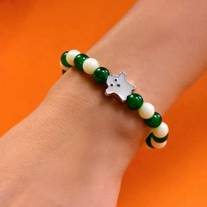 Luminous Halloween bracelet with green beads and ghost charm shown on a wrist