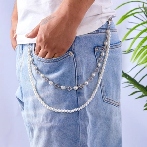 Close-up of double-layer pearl pants chain with clover charm on denim jeans