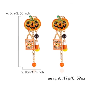 Detail of Halloween drop earrings with pumpkin face, candy bag charms and rhinestones