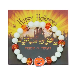 Detailed view of luminous beads and orange pumpkin charm on Halloween beaded bracelet