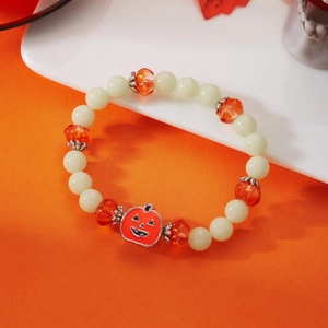 Macro shot of Halloween ghost pumpkin bracelet with luminous beads and orange pumpkin charm