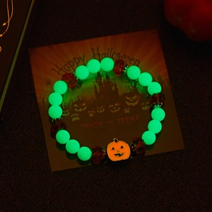 Glow-in-the-dark Halloween bracelet with orange pumpkin charm and luminous green beads
