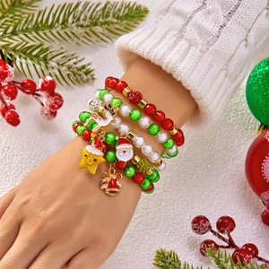 Nahaufnahme von Weihnachtsarmbändern mit Perlen und Weihnachtsanhängern am Handgelenk