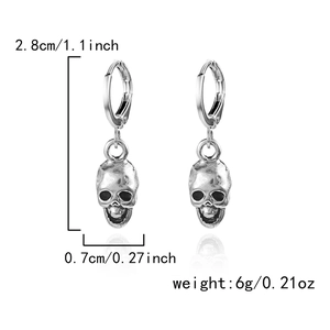 Detail view of silver skull drop earrings with dimensions of 2.8cm height and 0.7cm width