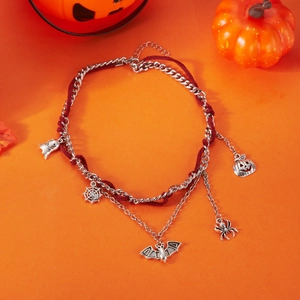Detalle de collar de Halloween de varias capas con dijes plateados y cordón de terciopelo rojo