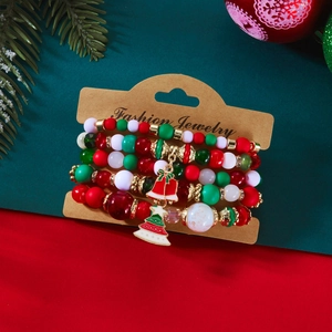 Détail du set de bracelets de Noël avec cloches rouges et breloques de sapin vert