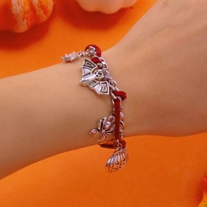 Primer plano de pulsera de Halloween con dijes de murciélago, araña y calabaza de plata