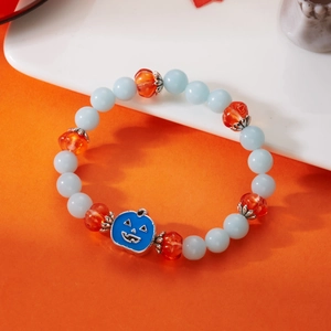 Detail of Halloween beaded bracelet featuring a blue enamel pumpkin ghost charm and beads