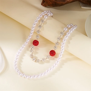 Detail of double-layer necklace with white pearls, red crystal beads and silver disco balls