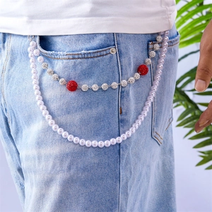 Detail of double-layer pant chain with white pearls and sparkling rhinestone balls on denim