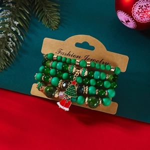 Détail d'un ensemble de bracelets de Noël avec perles vertes et breloques de fête