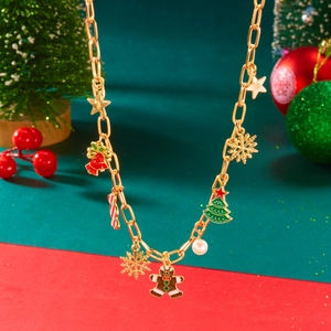 Dettaglio della collana dorata con ciondoli natalizi come albero e omino di pan di zenzero