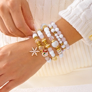 Vue détaillée des bracelets de Noël avec breloques bonhomme de neige et flocon sur mannequin