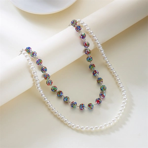 Hip hop layered necklace with white pearls and colorful rhinestone beads on a white roll
