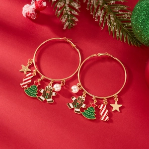 Dettaglio degli orecchini a cerchio dorati di Natale con ciondoli di pan di zenzero