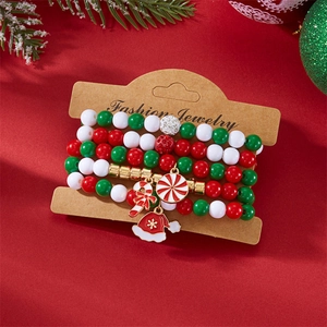 Weihnachts-Armbandset mit Perlen und Anhängern auf festlichem rotem Hintergrund