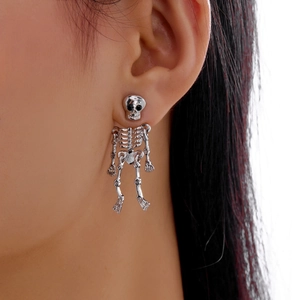 Macro side view of silver gothic skeleton drop earrings worn on ear for Halloween