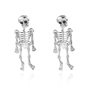 Detailed close-up of silver skull earrings with black bead eyes and polished metal finish
