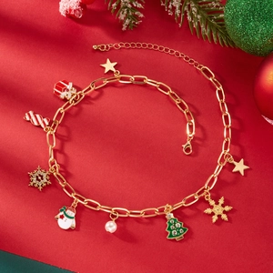 Dettaglio del bracciale natalizio dorato con ciondoli a fiocco di neve e pupazzo di neve