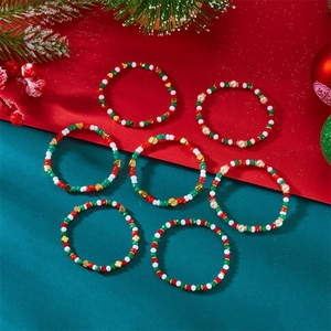 Flachbild von sieben Weihnachts-Perlenarmbändern mit festlichen Motiven in Rot und Grün