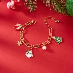 Dettagli del bracciale natalizio con pupazzo di neve, albero e ciondoli su sfondo rosso