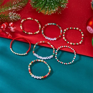 Detail von 7 Weihnachtsarmbändern mit Merry Christmas Love Anhängern auf Festtagshintergrund