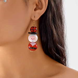 Détail des boucles d'oreilles de Noël en perles de bois portées par un mannequin
