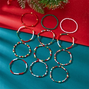 Detailansicht von 12 Weihnachtsarmbändern mit roten, grünen, weißen Perlen und Goldsternen