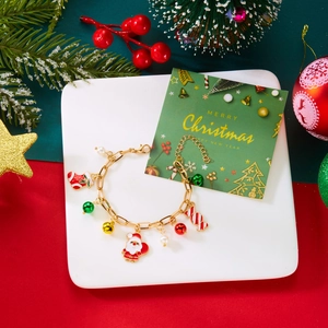Dettaglio bracciale natalizio con Babbo Natale, campanelli e perle su vassoio decorato