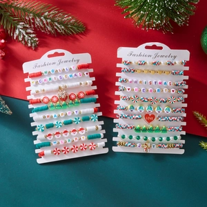 Detailed view of layered Christmas clay bead bracelets with holiday charms and festive letters
