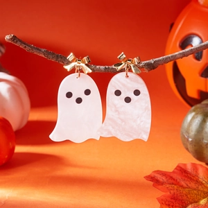 Ghost earrings with white marble texture on orange festive background detail view