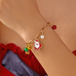 Dettaglio di un bracciale dorato festivo con Babbo Natale, perle e perline colorate