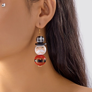 Gros plan de boucles d'oreilles en perles de bois Père Noël portées par un mannequin